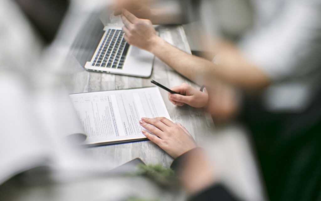 Personer gennemgår dokumenter ved den første dialog om behov og rammer for et projekt