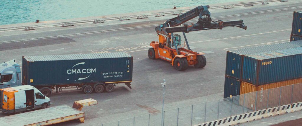 Containerterminal med lastbiler, gaffeltrucks og stablede containere